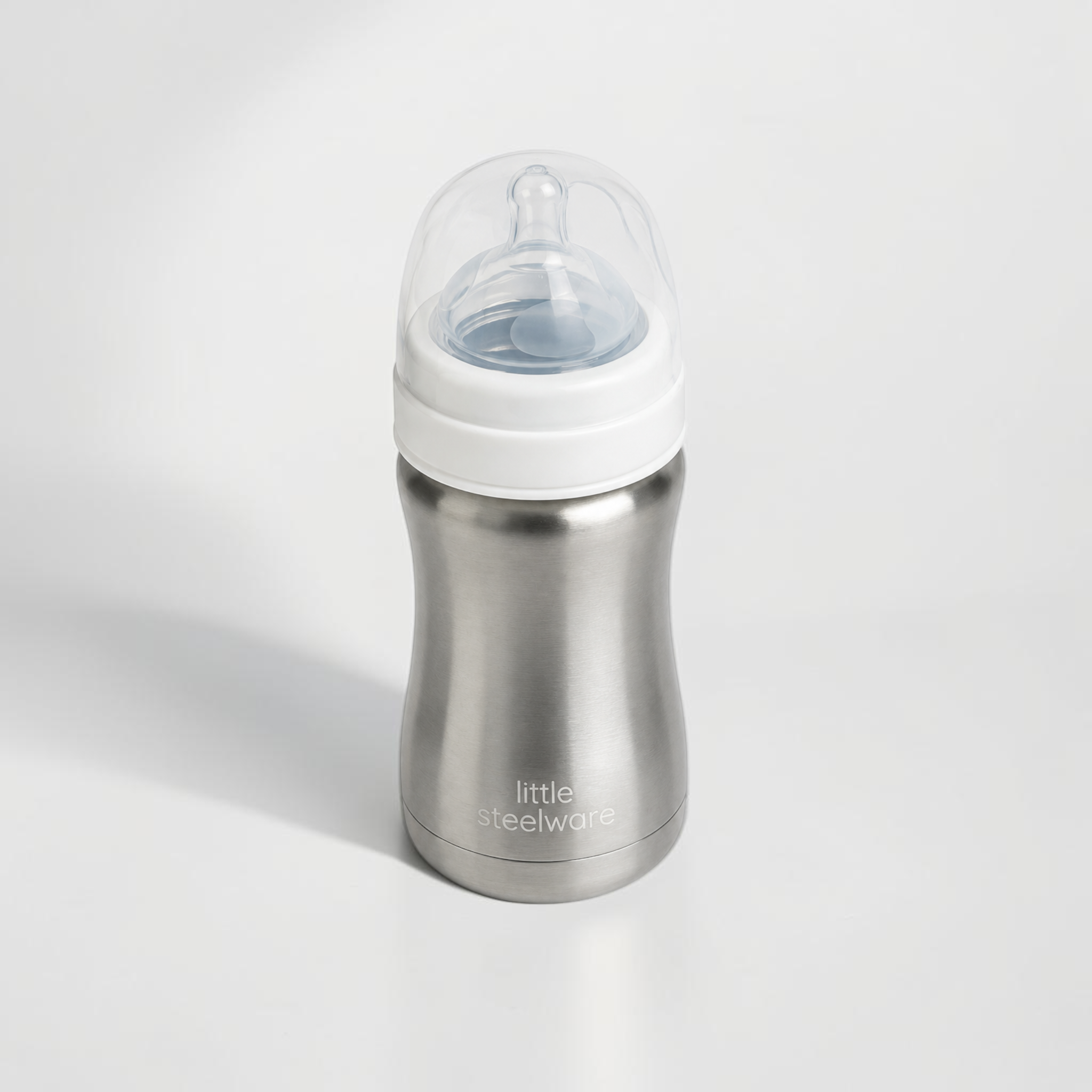 A stainless steel baby bottle with a white collar and a clear silicone nipple, branded 'little steelware' on the front, set against a clean white background.