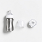 A stainless steel baby bottle with a white collar and clear silicone nipple, shown alongside a clear protective cap and a clear breast pump bulb on a clean white background. The brand name 'Little Steelware' is visible on the bottle.